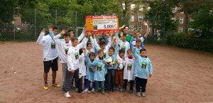 Die Kinder heben den Scheck in den Himmel von Hamburg. Foto: Florian Götze