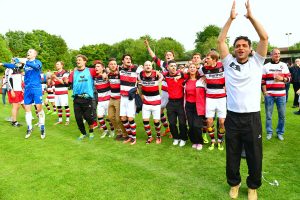 Nach dem Abpfiff: AFC-Trainer Algan (re.) und Fans feiern an der AJK den Aufstieg. Foto: KBS-Picture